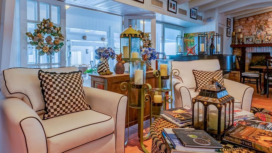 A hotel common area with plush sofas, decorative pillows, and rustic furnishings | Abaco Inn