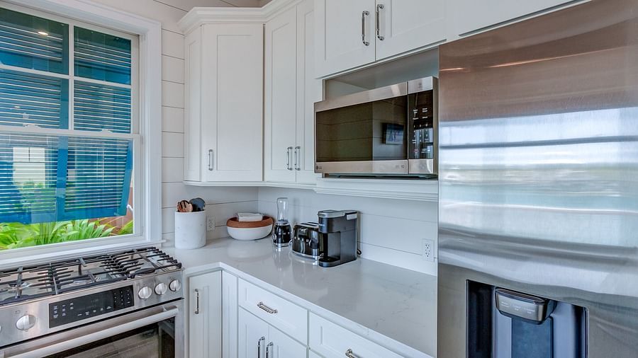 Kitchen with white cabinetry, a stainless steel fridge, and a stove | Abaco Inn