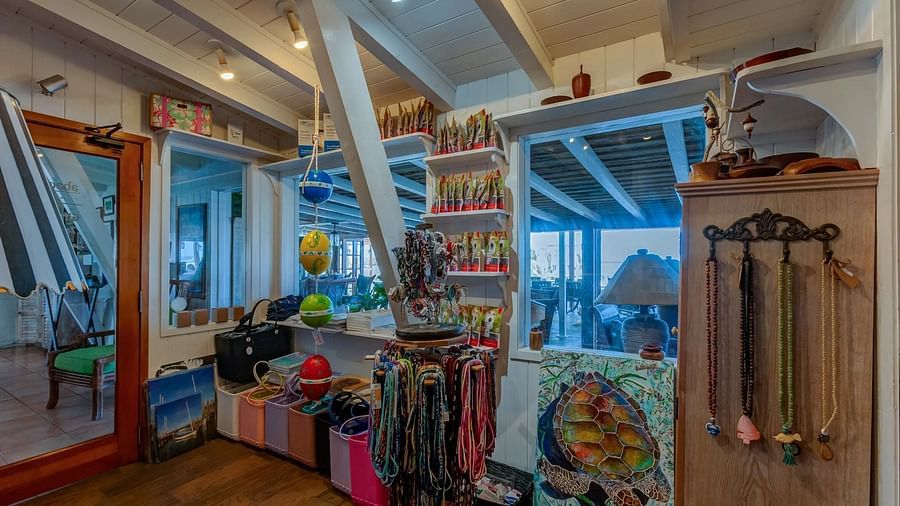 Coastal shop interior with shelves of swimwear, display tables, and racks holding accessories and vacation essentials.