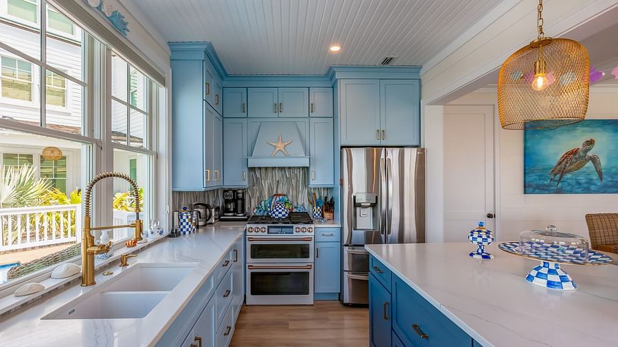 Bright, Blue and White themed kitchen with cupboards and windows that overlooks the sea at Abaco Inn.