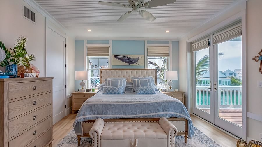 A bright and spacious bedroom with a huge bed and a sofa in the front, a cupboard, bedside table and glass doors that leads to the balcony with a sea view at Abaco Inn.