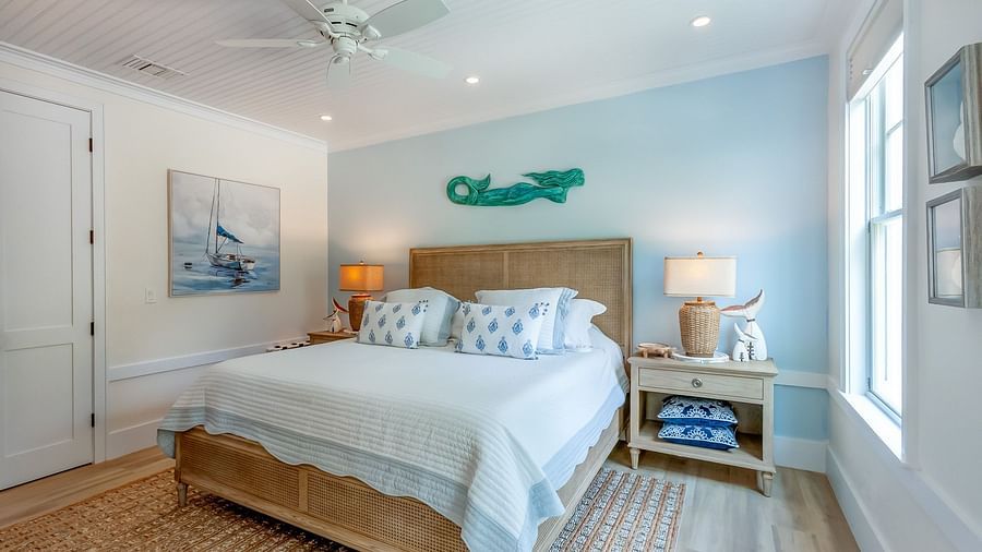 a bright bedroom with a comfortable huge bed, a bedside drawer, wall arts and a window at Abaco Inn .