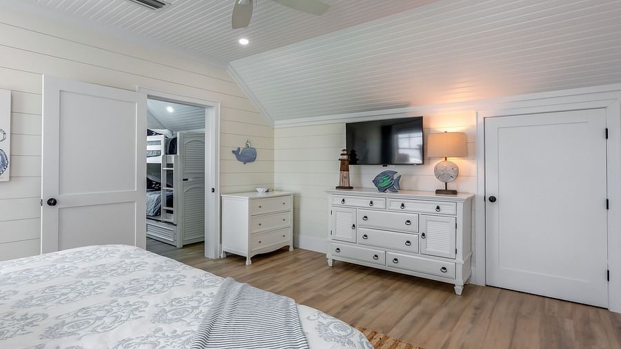 a spacious bedroom with a huge bed, cupboards, TV and wooden floor at Abaco Inn.
