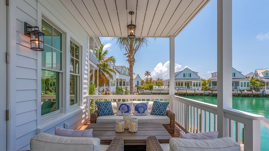 a balcony with a sitting area with comfortable chairs and table with a view of the sea at Abaco Inn.