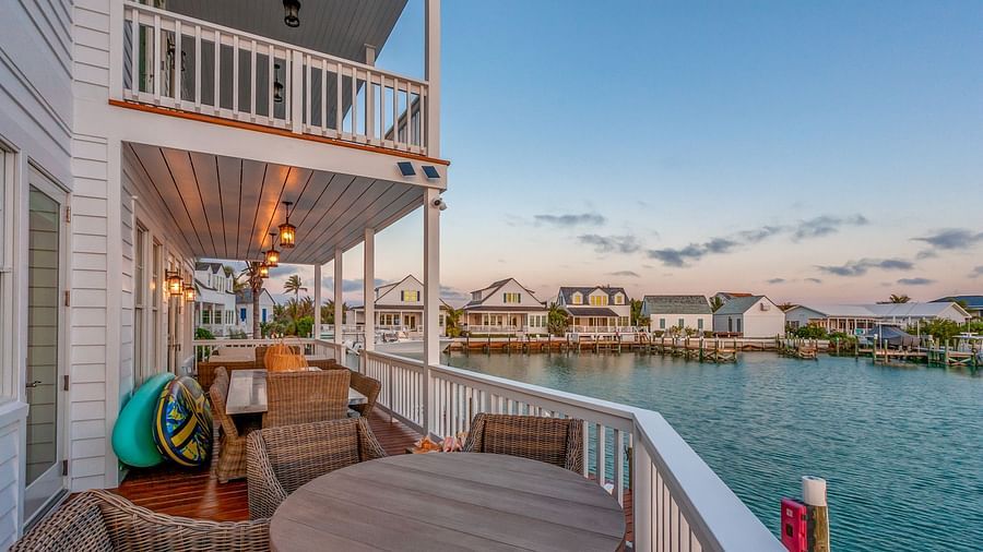 Outdoor sitting area on the dock with wooden tables and chairs and a view of the sea at Abaco Inn.