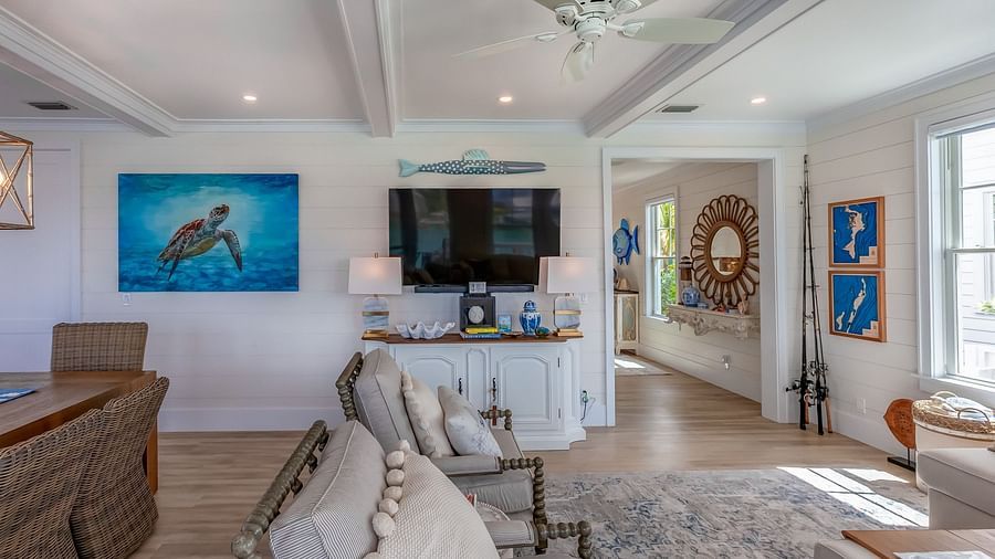 a sitting area with sofas, table, TV, cabinet and wall decors at Abaco Inn.