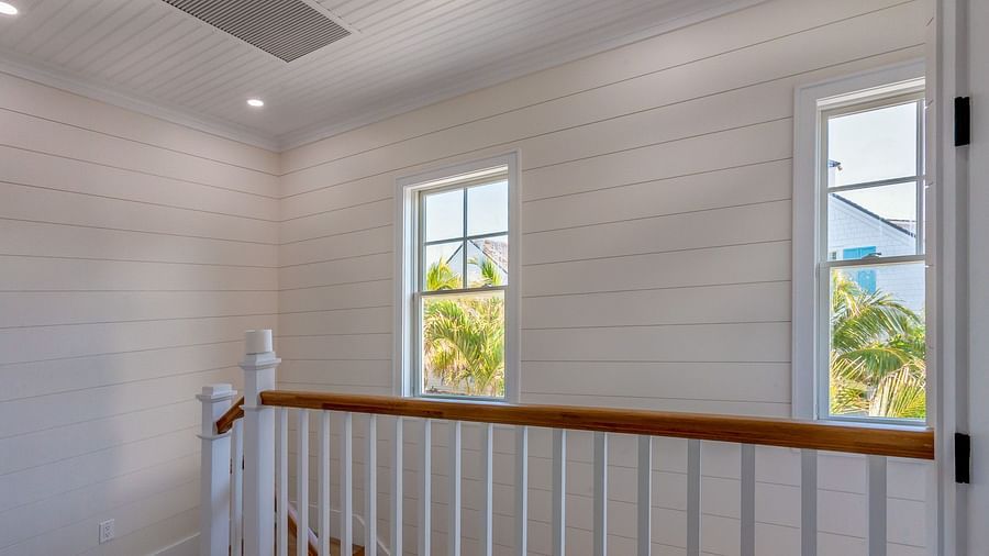 Stairways of Abaco Inn with white walls and windows overlooking greenery.