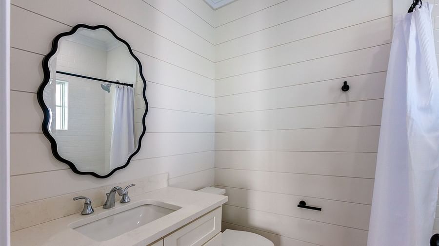 bathroom of Abaco Inn with a sink, mirror and a commode.