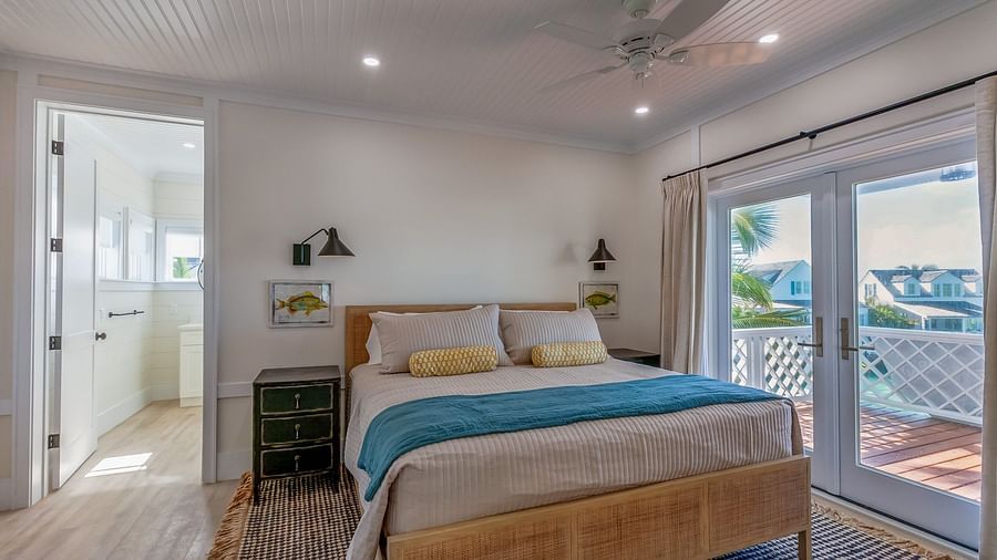 a bedroom with a double bed, a bedside drawer,  a door leading to the attached bathroom and a glass door leading to the balcony with a sea view at Abaco Inn.
