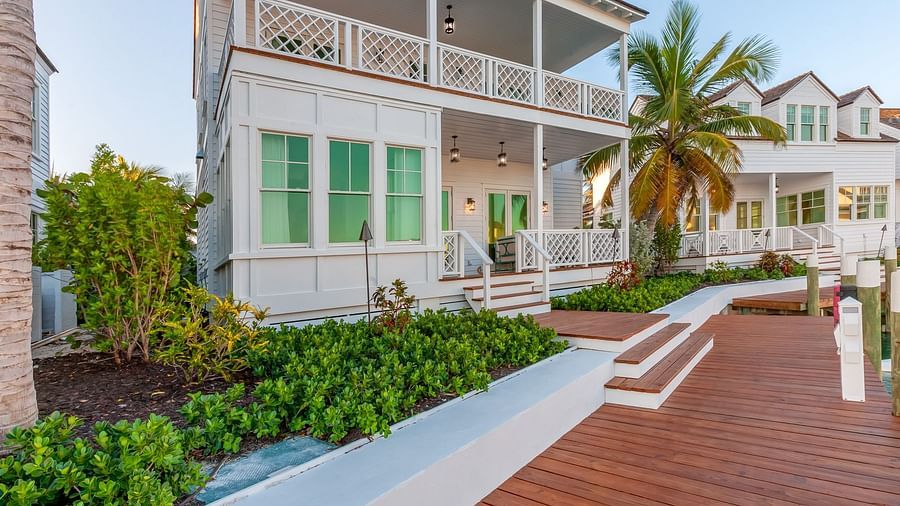 Facade of Abaco Inn with wooden dock and greenery.