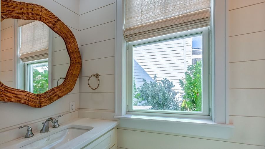 Bathroom with a sink , mirror and a window at Abaco Inn.