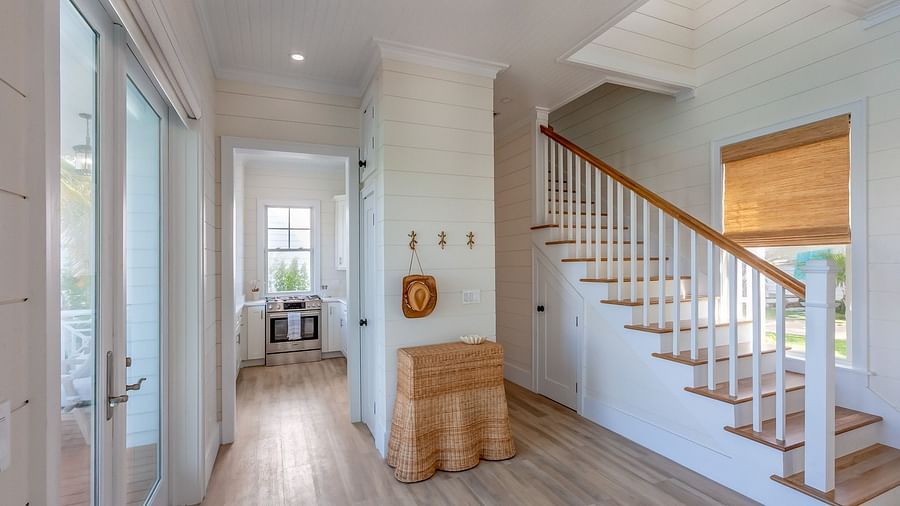 a corridor featuring a stairways, wooden floor, wall decors, and a glass door leading to the dock at Abaco Inn.