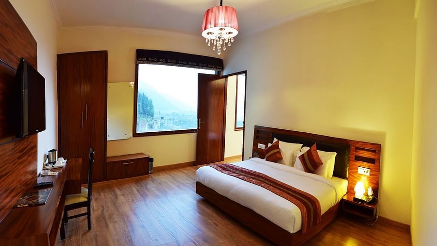 Image of a room with king size bed, cupboard, TV cabinet, windows  | DLS Serenity Resort and Spa
