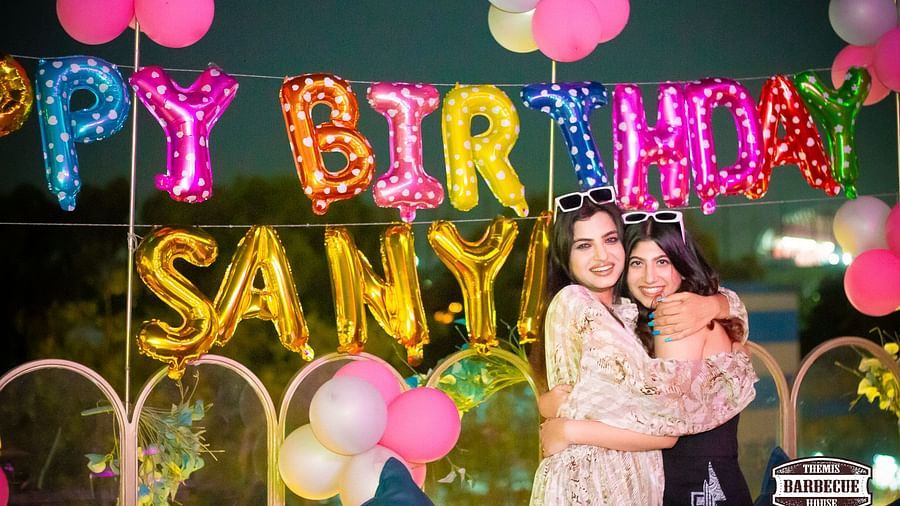 An image of a birthday party where two woman are hugging each other - Themis Barbecue House, NSP Pitampura