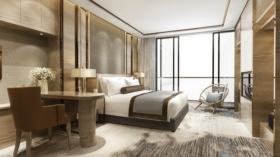 a double bedroom with a lounge area, wall-mounted TV, and a bedside table with a lamp 