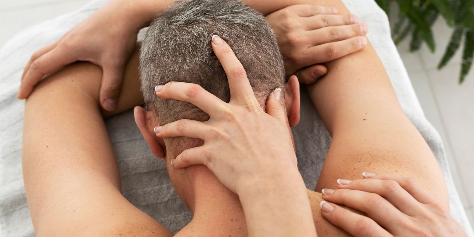 A relaxing massage with gentle hands working on the neck and shoulders of a patient.