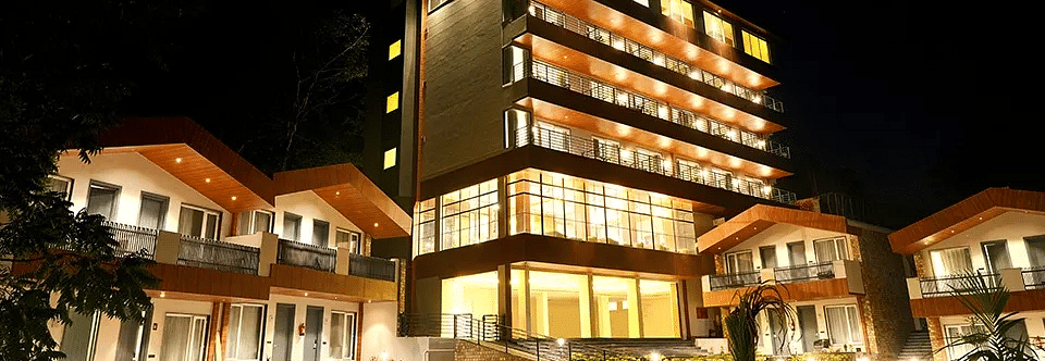 a facade image of a hotel premises featuring a vast lawn in the foreground