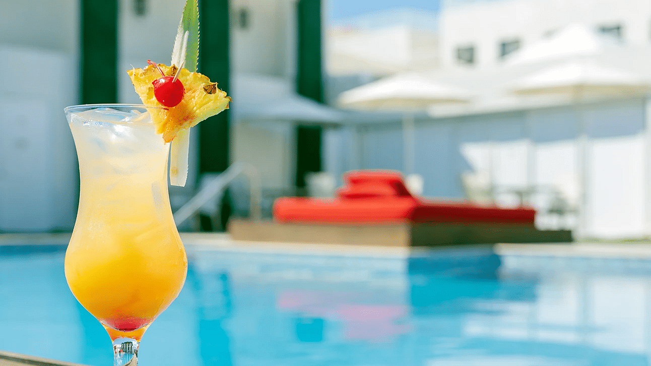 A cocktail with a fruit peel by the side of the pool - S Hotel Kingston, Jamaica