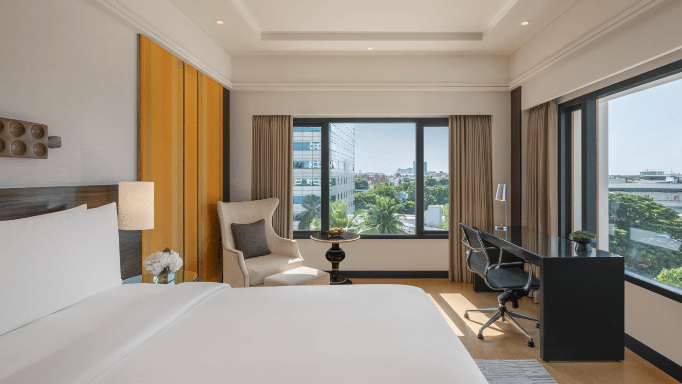 Bedroom with large window, desk, and bed at The Raintree, St. Mary’s Road.