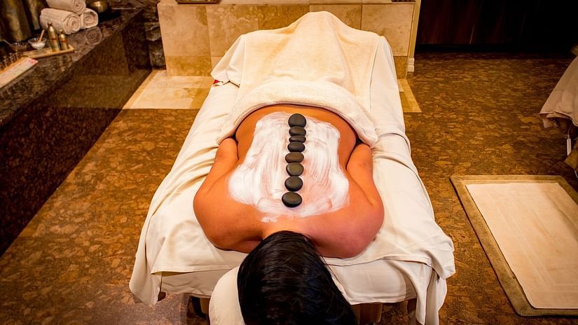 An individual lying down on a bed during spa