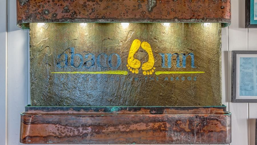 Metal signboard with Abaco Inn logo mounted on wall | Abaco Inn