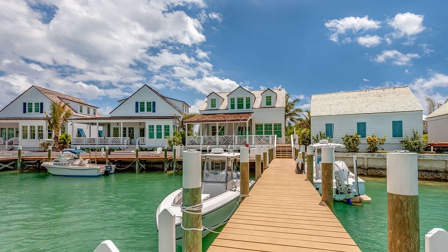Multiple waterfront villas with private docks along a calm bay with clear skies | Abaco Inn