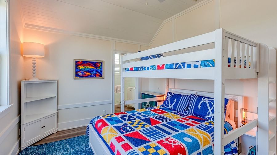Children's bedroom with a white bunk bed and colorful bedding | Abaco Inn
