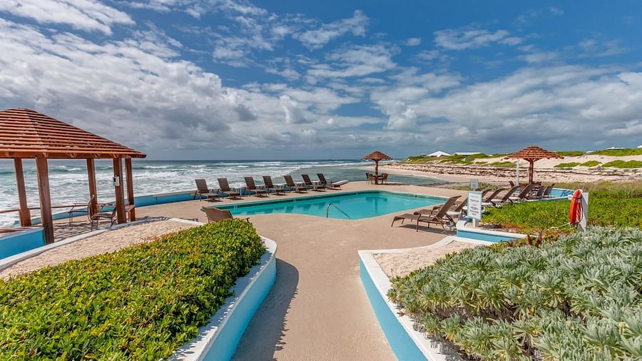 Beachside path with wooden railing and gazebos by the ocean | Abaco Inn