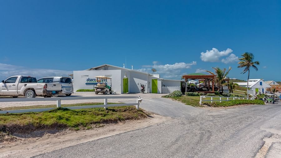 Parking area with cars and white buildings | Abaco Inn