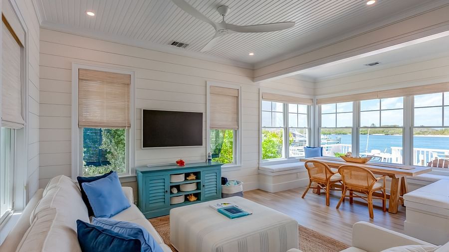 Bright furnished living room with a flat-screen TV and large windows | Abaco Inn