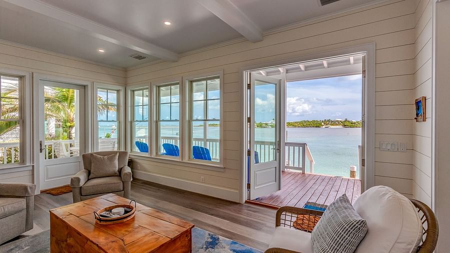 Living room with wicker chairs, a wooden coffee table, and a waterfront view | Abaco Inn