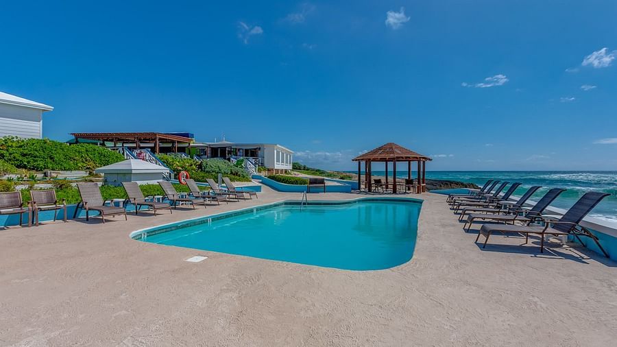 Pool area with lounge chairs and a small gazebo | Abaco Inn