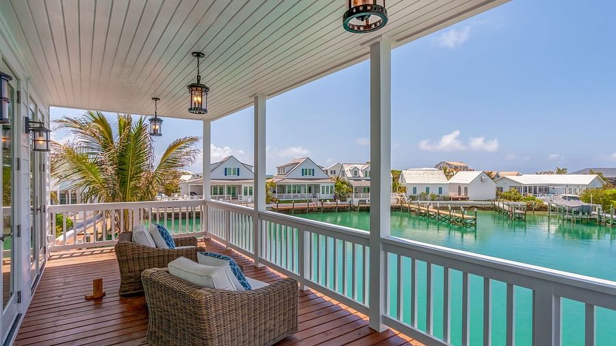 A wooden balcony with comfortable chairs with a view of the sea at Abaco Inn.