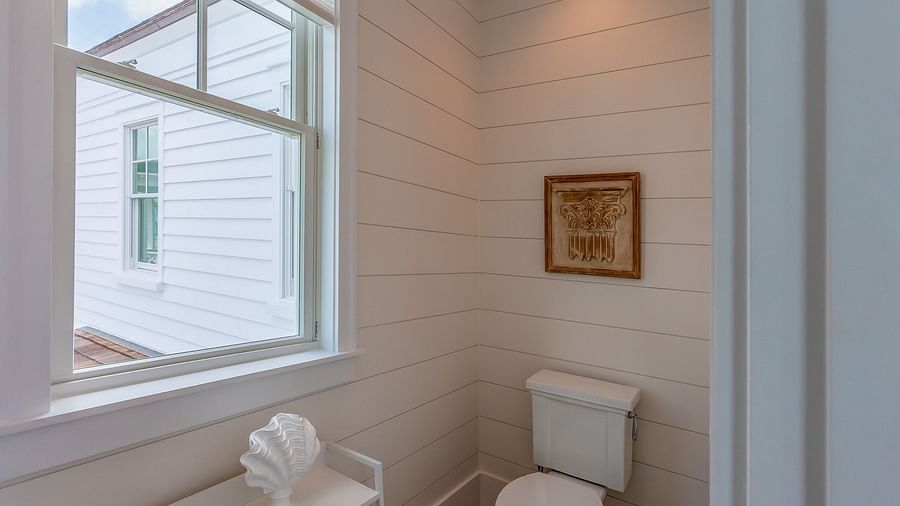 A washroom with white walls and a toilet at Abaco Inn.
