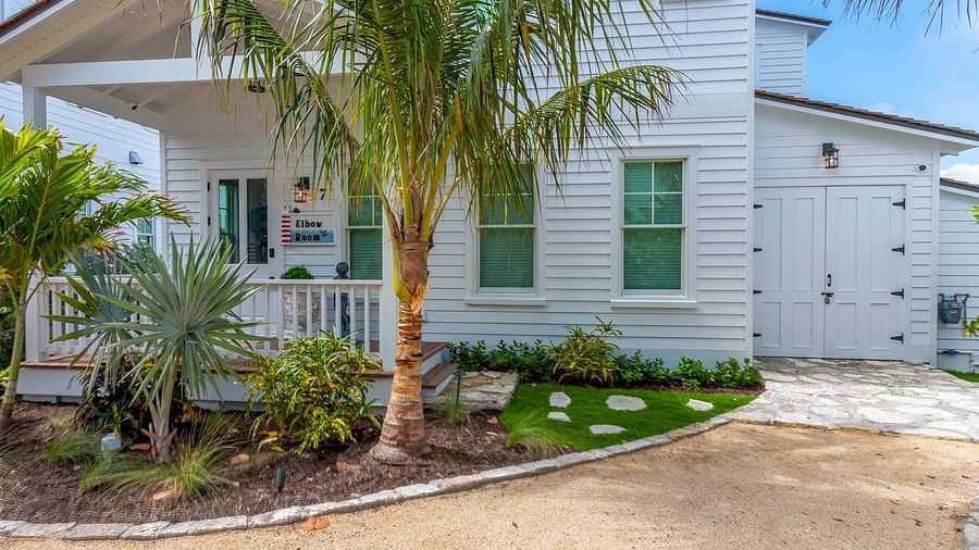 Facade of a white house with palm trees at Abaco Inn.