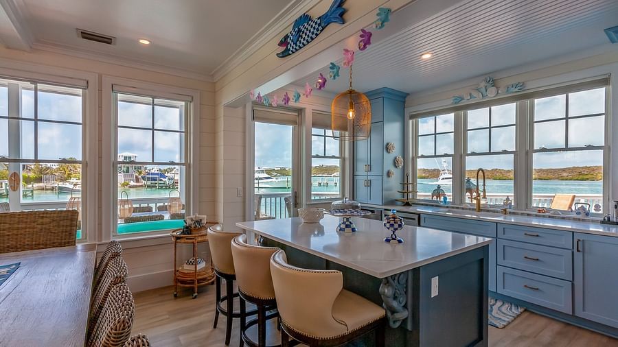 A bright and spacious kitchen with marble top table, chairs and windows with the sea view at Abaco Inn.