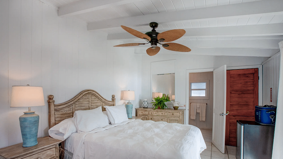 Bedroom with two beds, ceiling fan, and warm lighting | Abaco Inn