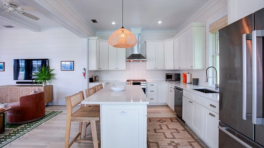 Open kitchen with a central island, bar stools, and modern appliances | Abaco Inn