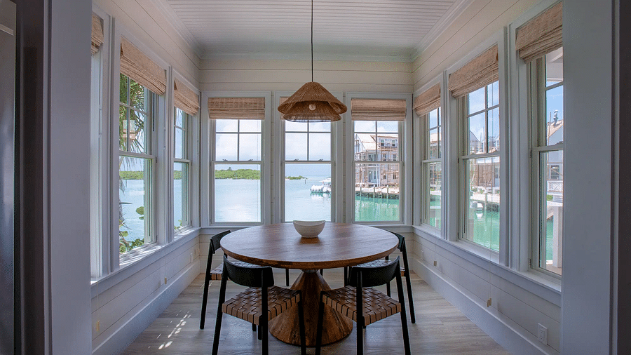 Cozy dining nook with a round table and surrounding windows | Abaco Inn