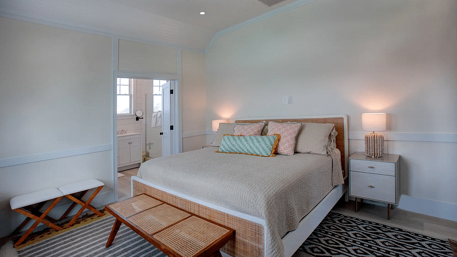Bedroom with a simple bed, wooden bench, and white walls | Abaco Inn