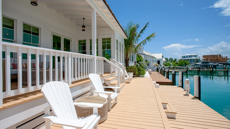 Outdoor deck with white lounge chairs offering waterfront views | Abaco Inn