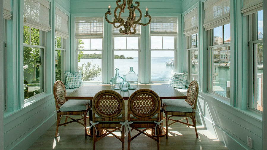 Dining area with a large chandelier and windows offering sea views | Abaco Inn