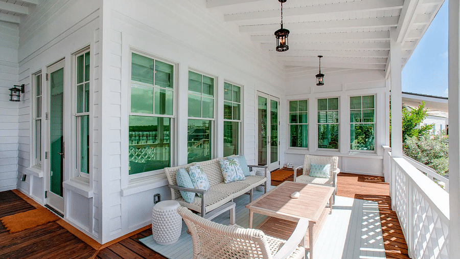 Enclosed porch with white wicker furniture and panoramic water views | Abaco Inn