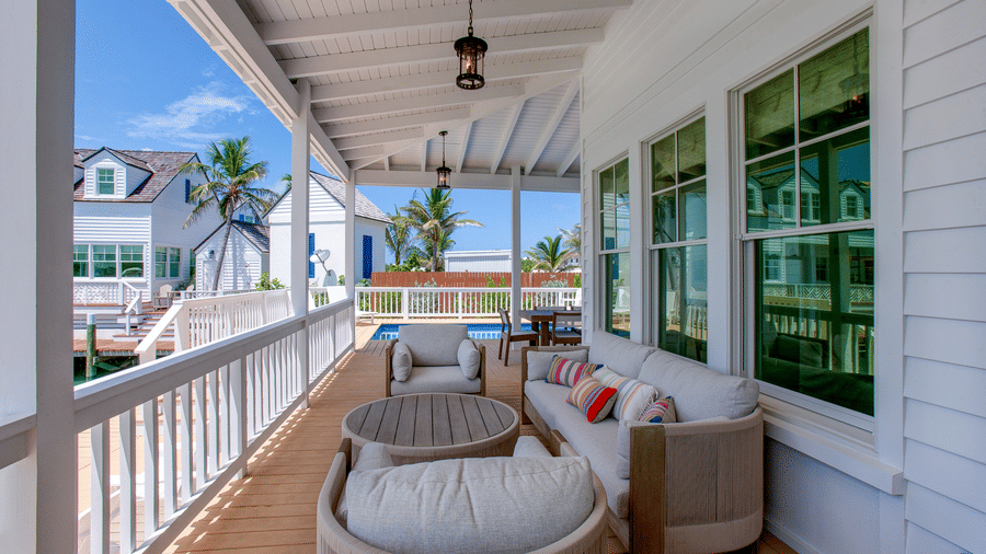 A spacious veranda with outdoor seating, ceiling fans, railing, and views overlooking Abaco Inn and the surrounding water.