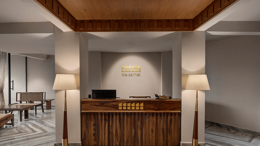 A reception desk with two lamps on either side of the desk - The Samai, Bhimtal