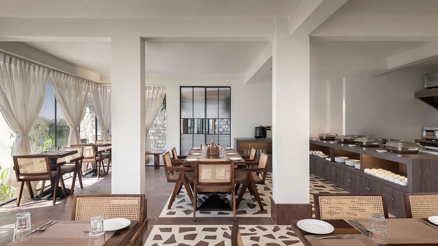An interior view of a restaurant with wooden chairs and tables - The Samai, Bhimtal