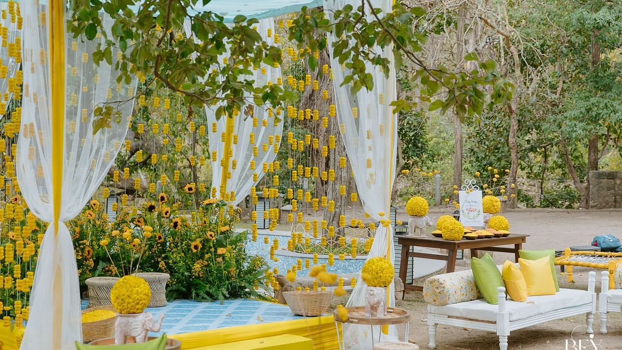 An outdoor space with decorated seating and fabric hangings, possibly for an event or celebration.