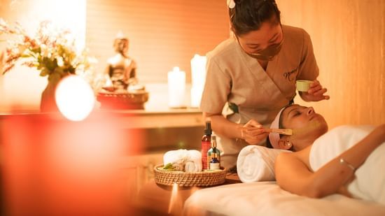 A masseur applying a face serum to the client inside the Spa - Karma Lakelands.
