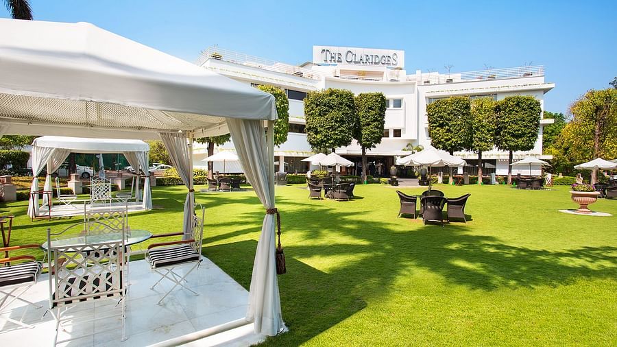 a bright image of the landscape of the claridges garden - The Claridges New Delhi