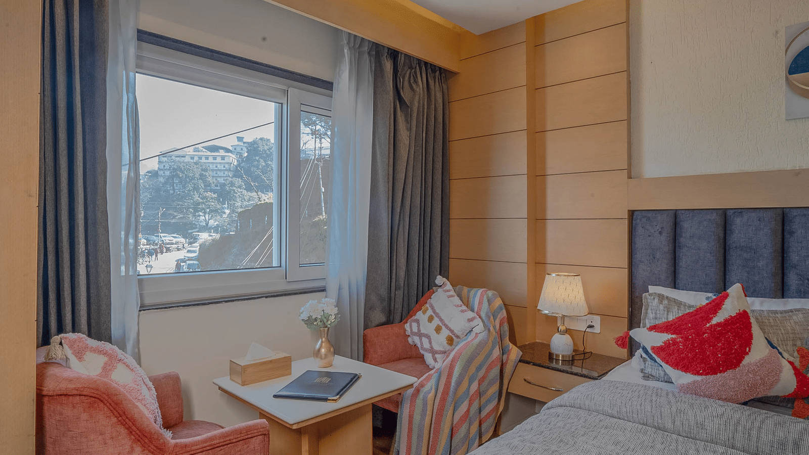 A bedroom with a seating area and window view at Perfectstayz Premium at Mall Road Hotel Super, Mussoorie.